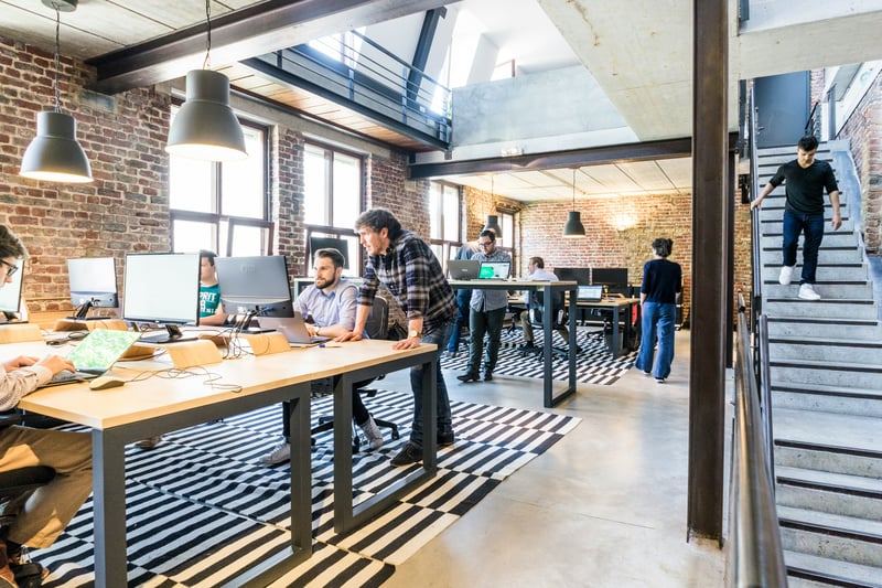 Startup team collaborating in a modern office, reflecting the shift from founder-led work to a more structured team-based revenue process.